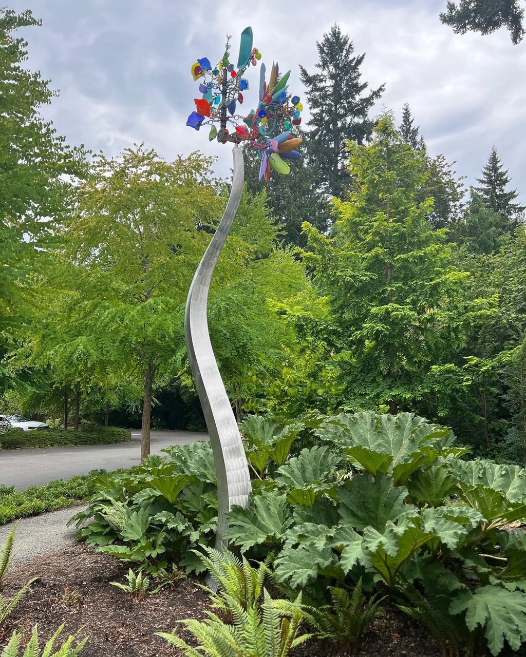 colorful garden sculpture in amongst giant foliage plant