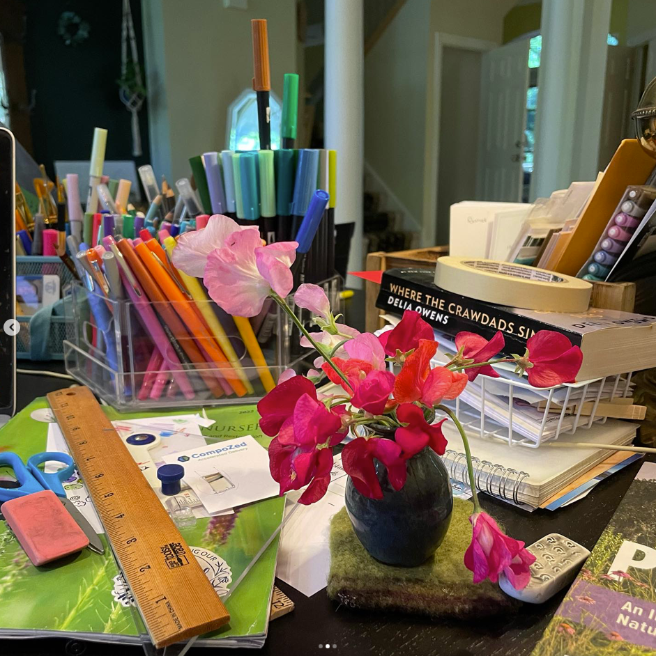 small vase of pink flowers on a craft table