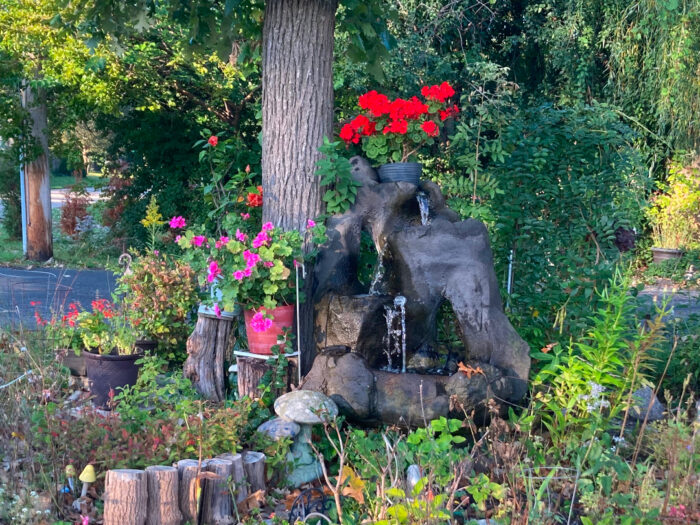 three-level fountain in the middle of this small garden