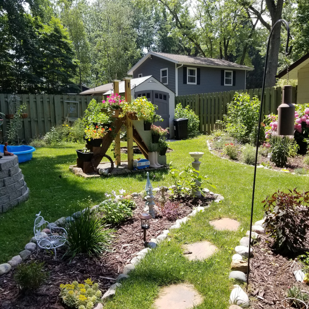 container plant ladder in the middle of several garden beds