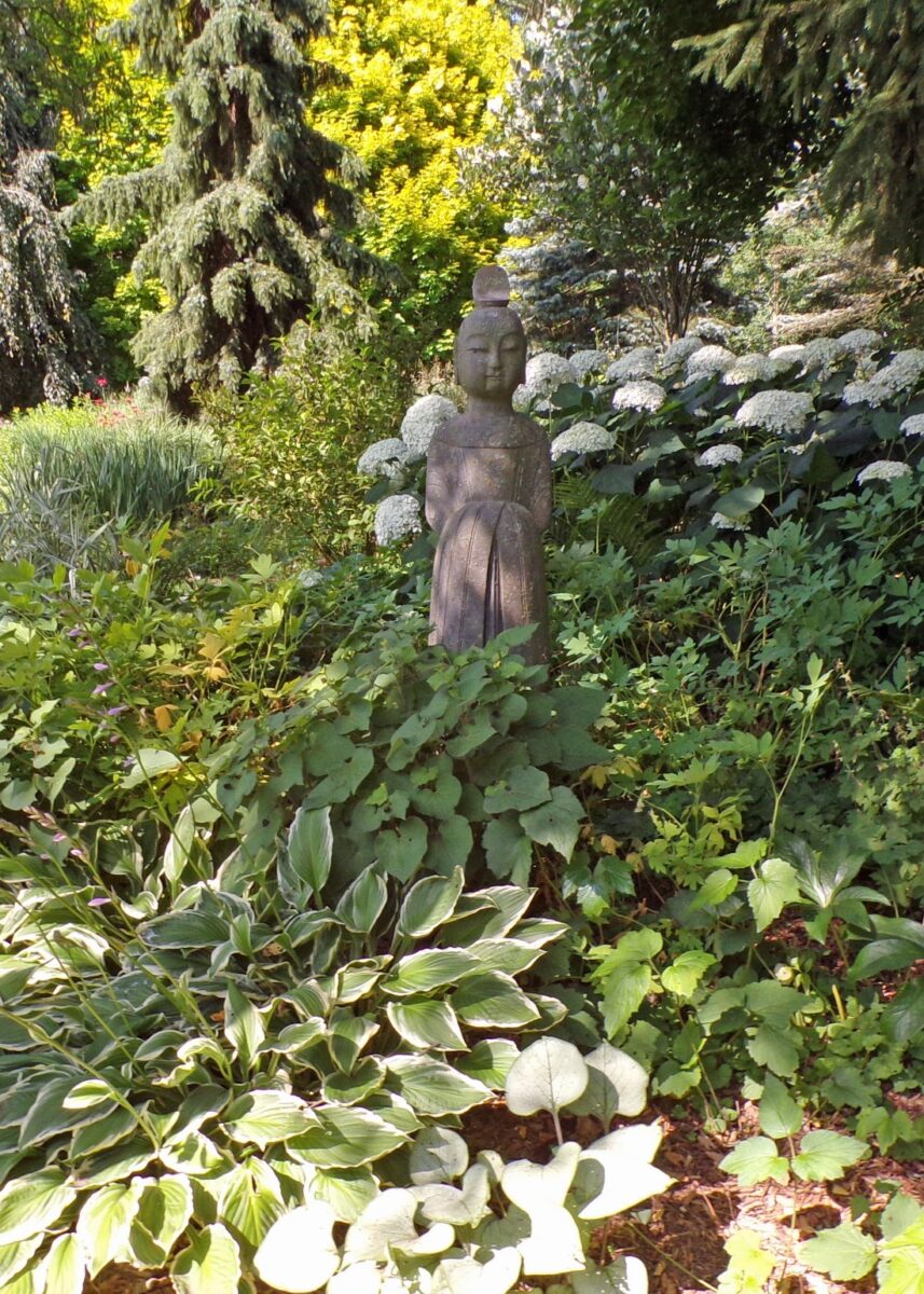 another view of the statue in the shade garden with hydrangea behind