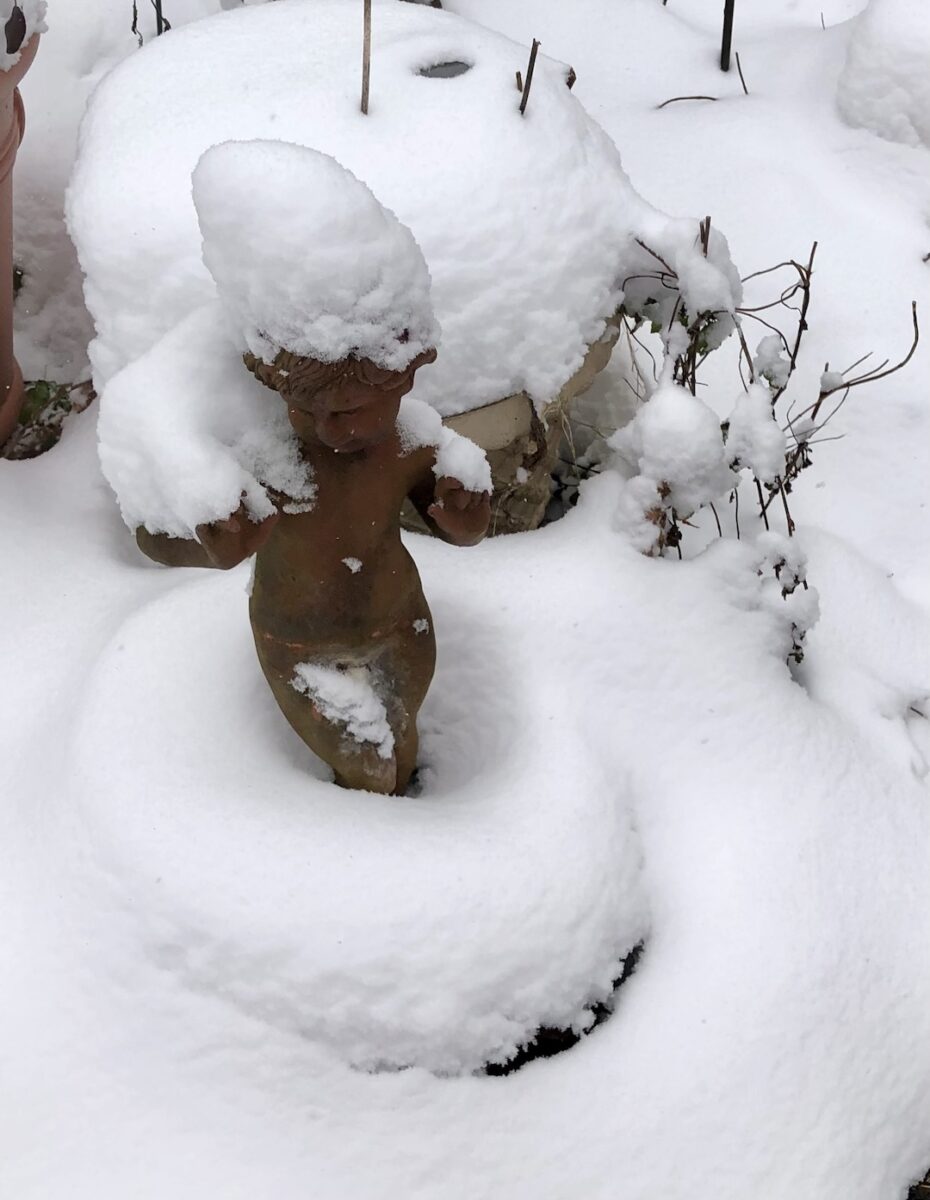 small garden statue covered in snow