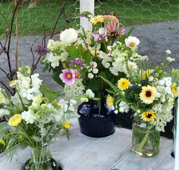 three bouquets of white, yellow, and pink flowers