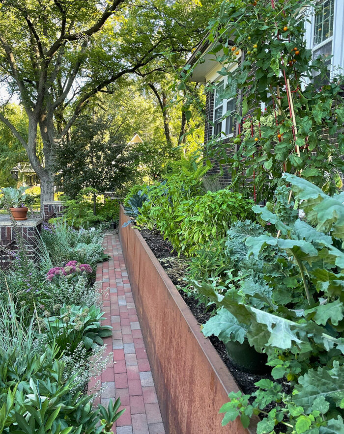tiered garden beds with veggies and pollinator plants