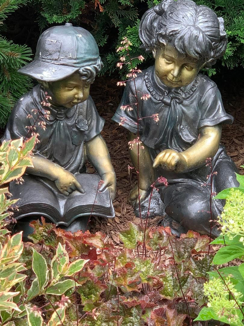 statues of two young children in the garden