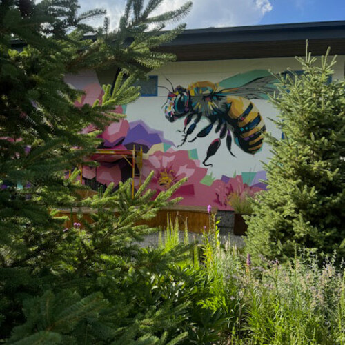 view of bee mural between conifers