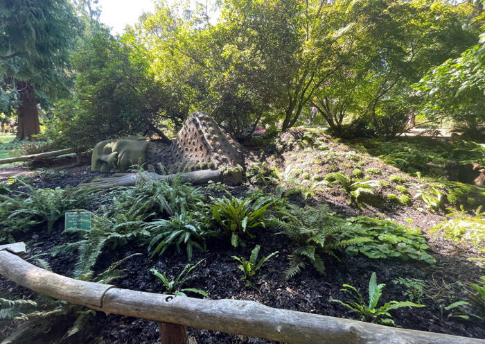 shade garden with plant covered sculpture