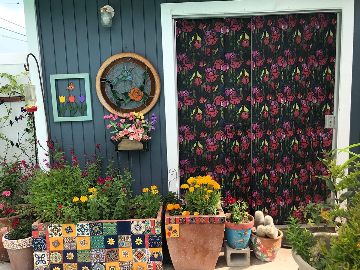 pool shed with colorful door and containers with flowers surrounding