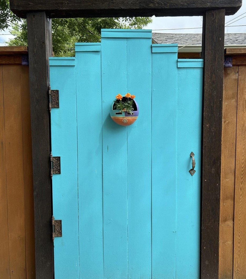 blue garden gate with small flower pot