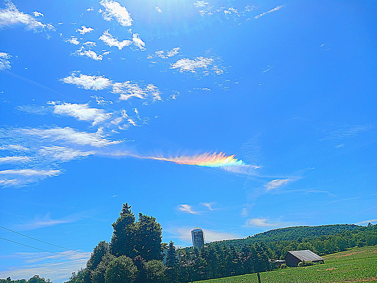 streak of rainbow light in sky from sun