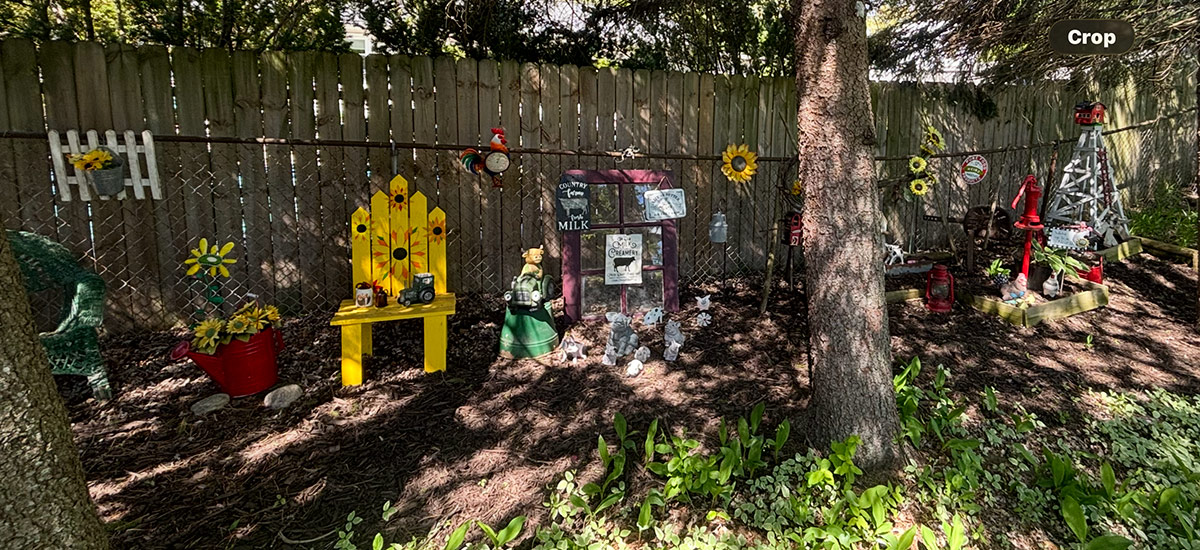 shady garden border with lots of garden art