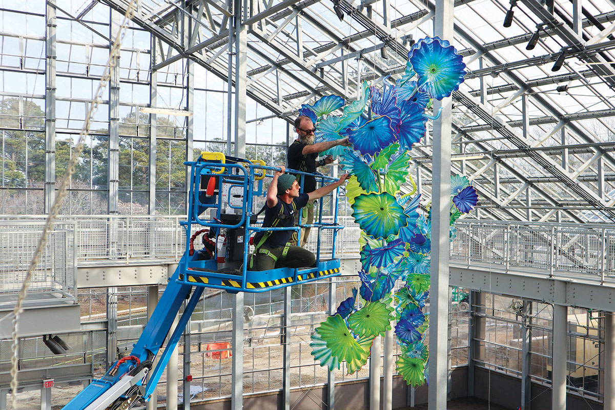 workers hanging Chihuly artwork in conservatory