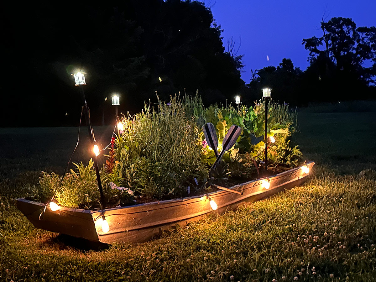 Old boat being used as a raised bed in a cottage garden