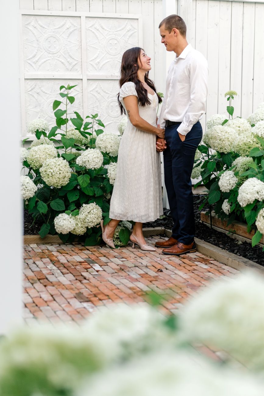 couple in white hydrangea garden, vintage brick path, and decorative Victorian tiles