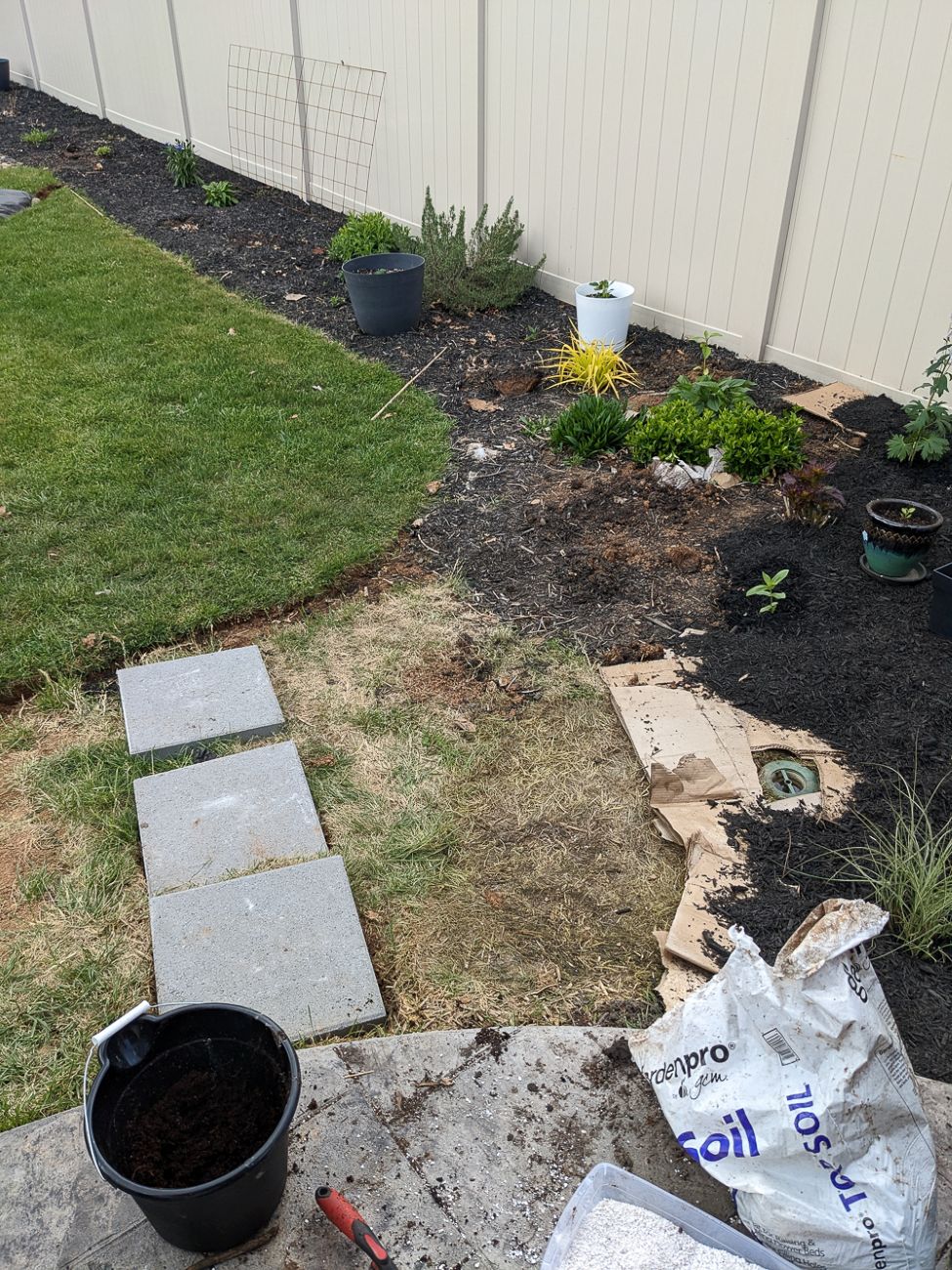 Stepping-stone path being installed through expanding backyard garden beds