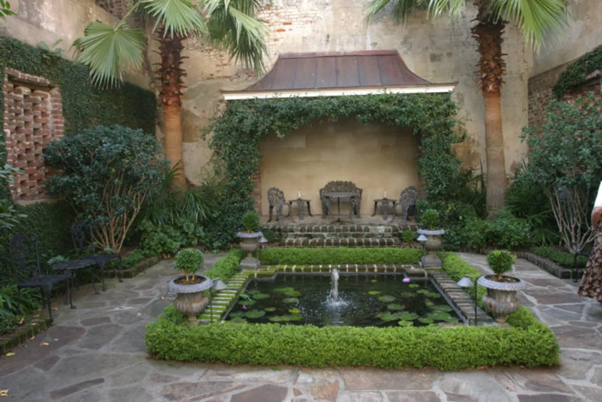 Charleston South Carolina courtyard, reflecting pool, fountain, boxwood hedges, palm trees, formal garden