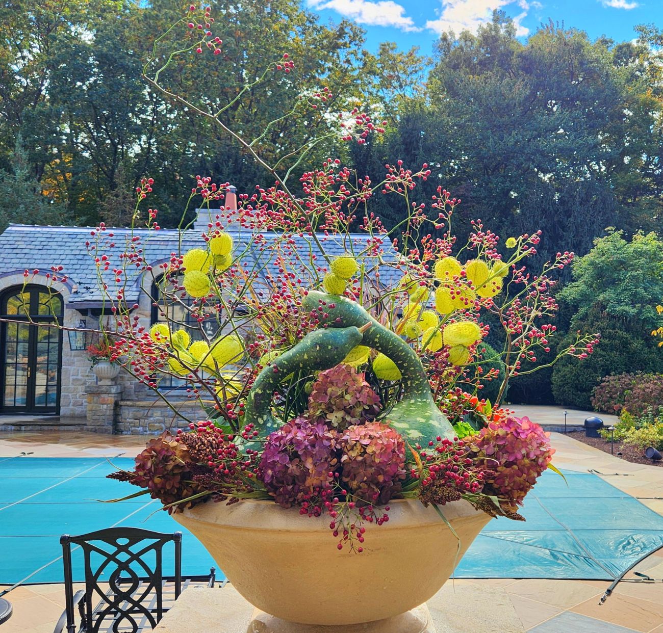 Autumn bowl arrangement, curved bottle gourds, wild rose hips, balloon plant seed pods, dried panicle hydrangea flowers