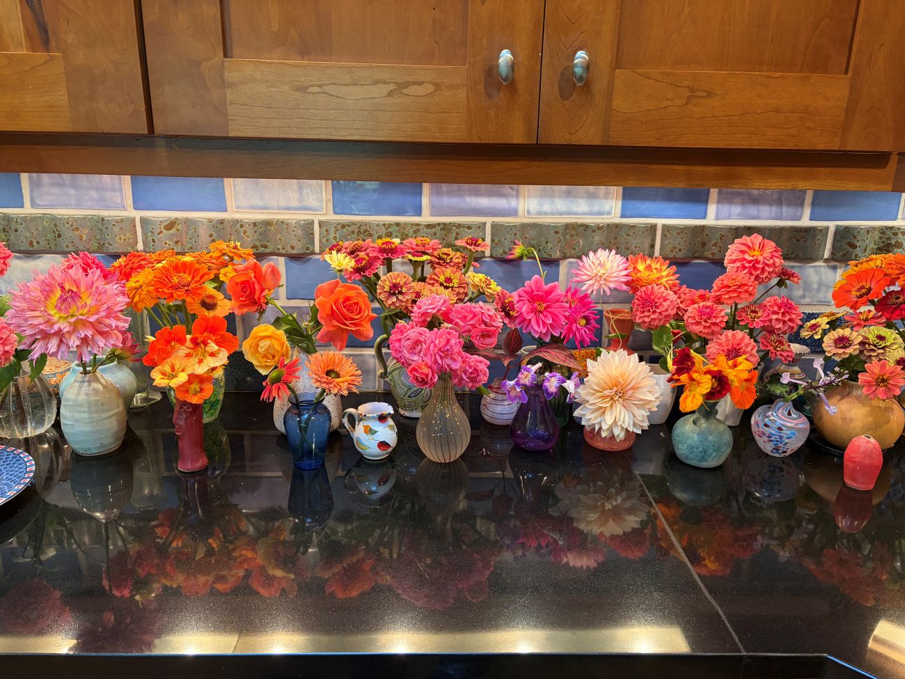 Cut flowers arranged in individual vases, dahlia cultivars, colorful zinnias, roses, coneflowers, nasturtiums, autumn cutting garden harvest