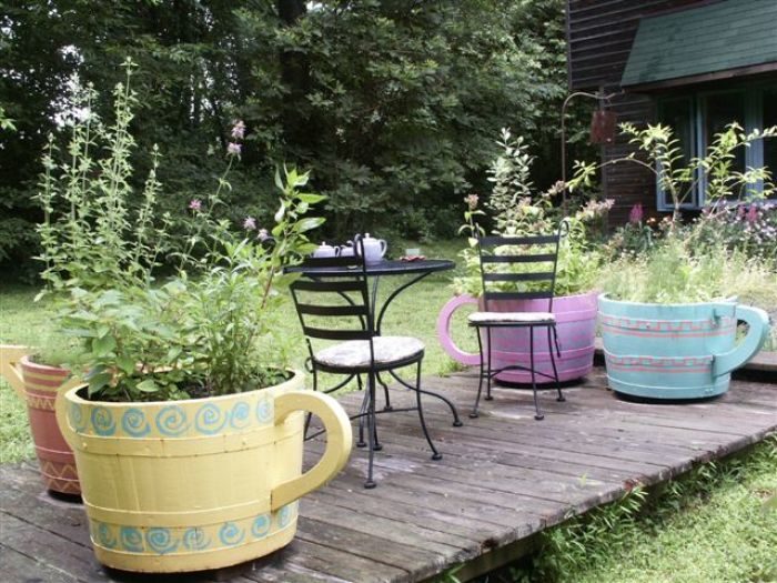 garden deck with colorful container and small table ready for tea party